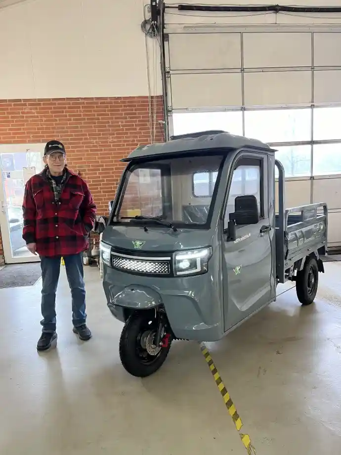 Fornøjet ejer ved sin nye grå LuxCap kabinescooter med tiplad